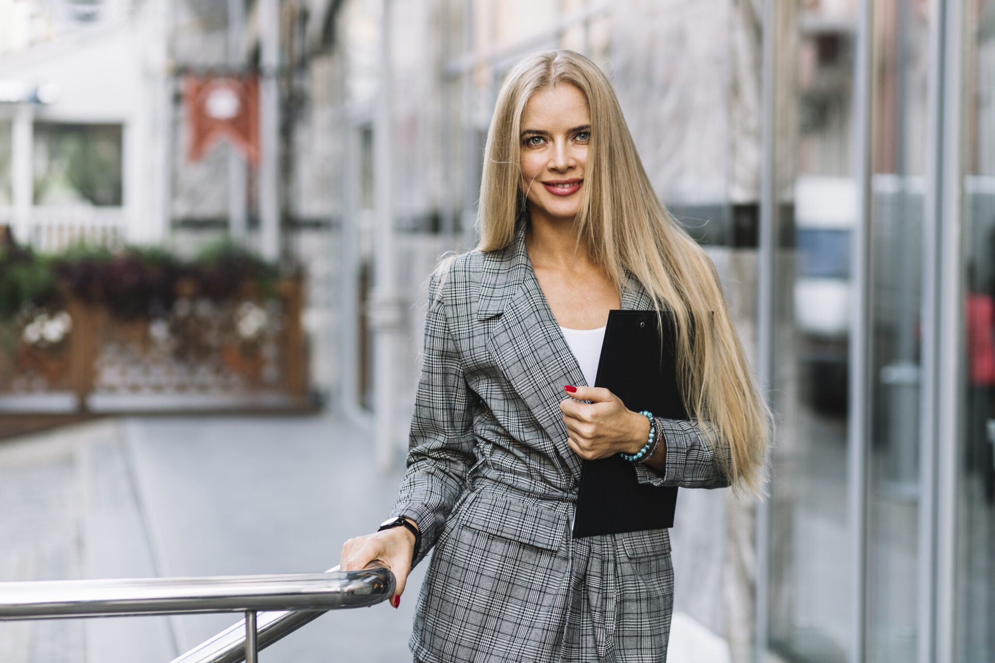 femme-d-affaires-elegant-avec-le-presse-papier-en-ville